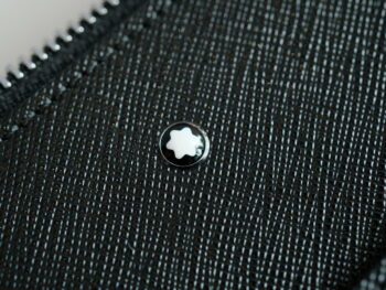 Clutch cầm tay Montblanc Unisex Sartorial Black 128570 gia công tại Italy với thiết kế nhỏ gọn được làm từ da bê màu đen in hoa văn Saffiano, logo được đặt ngay giữa tạo nên điểm nhấn khi cầm. Chiếc ví có kích thước 280*30*180 mm, có 2 ngăn phụ trước, 1 ngăn chính có lớp lót bên trong và vài ngăn nhỏ khá tiện cho cất giữ đồ. Chiếc ví có dây đeo cổ tay có thể tháo rời rất tiện. 9 Clutch cầm tay Montblanc Unisex Sartorial Black 128570 - Ảnh 5