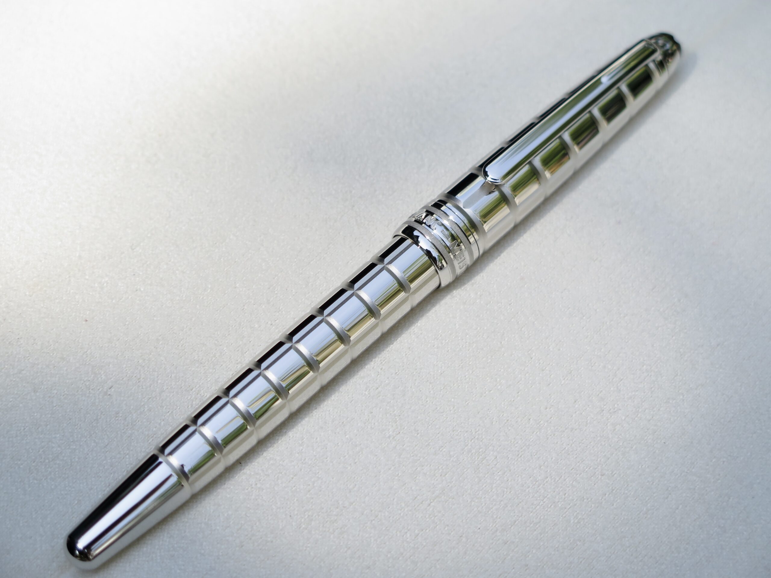 Vẫn mang thiết kế đặc trưng của dòng Solitaire nhưng mẫu bút Montblanc Platinum Plated Facet mang cho người dùng ấn tượng rất đặc biệt. Bút được mài cắt (facet) tỉ mỉ từ một khối thép mạ Platinum khá dầy để tạo thành những đường sọc nổi 3D trải dài suốt thân bút. 6 Bút Montblanc Meisterstuck Solitaire Platinum Plated Facet Rollerball Pen 38247 - Ảnh 6
