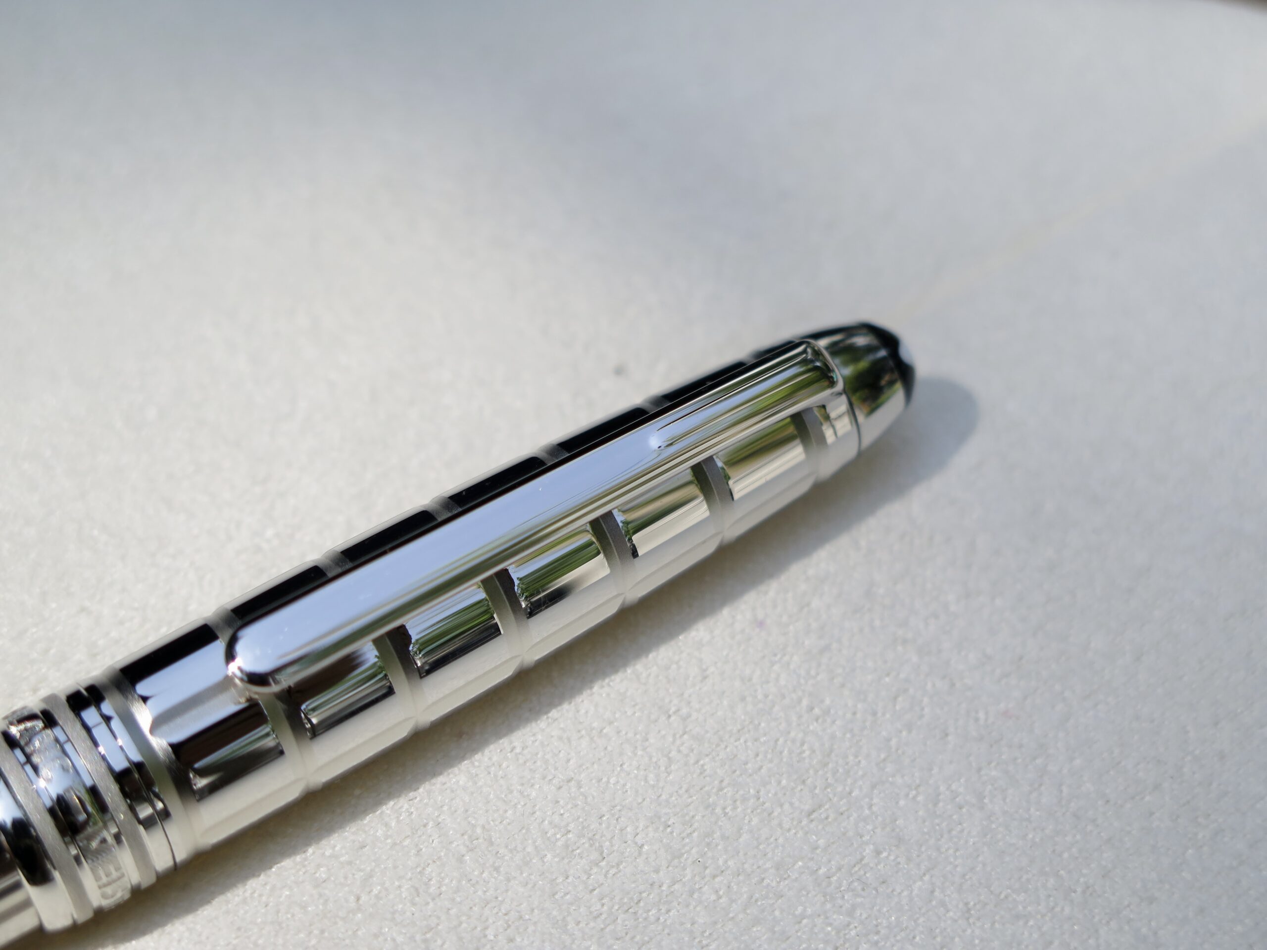 Vẫn mang thiết kế đặc trưng của dòng Solitaire nhưng mẫu bút Montblanc Platinum Plated Facet mang cho người dùng ấn tượng rất đặc biệt. Bút được mài cắt (facet) tỉ mỉ từ một khối thép mạ Platinum khá dầy để tạo thành những đường sọc nổi 3D trải dài suốt thân bút. 4 Bút Montblanc Meisterstuck Solitaire Platinum Plated Facet Rollerball Pen 38247 - Ảnh 4