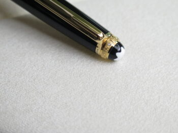 Montblanc Meisterstuck Classquie 75th Anniversary Special Edition là phiên bản đặc biệt được ra mắt năm 1999 nhân dịp kỷ niệm 75 năm ngày ra mắt dòng bút Meisterstuck. Điểm khác biệt lớn nhất của phiên bản này là phía trên đỉnh viết cũng được trang trí bằng một vòng tròn mạ vàng mang dòng chữ “75 Years of Passion” đính một viên kim cương thay cho chữ O. 8 Bút chì Bút Montblanc Meisterstuck 75th Anniversary Special Edition Ballpoint Pen - Ảnh 4