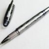 Bút Montblanc StarWalker SpaceBlue Metal Fineliner 130220 gây ấn tượng mạnh mẽ bởi toàn bộ phần thân và nắp được chế tác từ kim loại cao cấp, phủ lớp Ruthenium tối màu mang hơi hướng tương lai. Mặt trên của lớp vỏ được khắc họa tỉ mỉ các hoa văn mô phỏng cấu trúc Widmanstätten – những đường vân tinh thể đan xen đặc trưng chỉ xuất hiện trên các lõi thiên thạch rơi xuống từ vũ trụ. Sự kết hợp này mang lại cho cây bút một diện mạo đầy nam tính, bí ẩn và đầm tay khi sử dụng. Điểm nhấn đắt giá nhất nằm ở phần đỉnh nắp. Dưới vòm trong suốt đặc trưng của dòng StarWalker, một thế giới vi mô mở ra với lớp nền màu xanh không gian sâu thẳm (Space Blue), làm nổi bật biểu tượng ngôi sao sáu cánh Montblanc màu trắng tinh khôi lơ lửng ở chính giữa, tựa như một hành tinh cô độc tỏa sáng giữa dải ngân hà huyền bí. Phiên bản bút còn là biểu tượng của tinh thần khai phá và khát khao chinh phục mọi giới hạn. 10 Bút Montblanc StarWalker SpaceBlue Metal Fineliner 130220 - IMG 4576